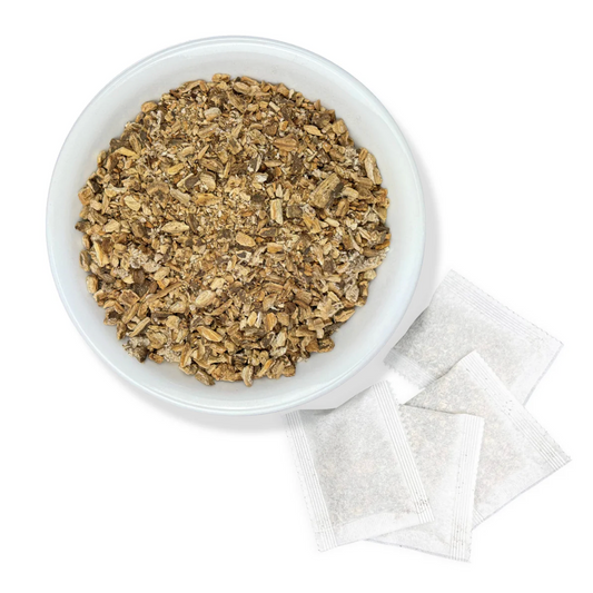 White bowl filled with tea leaves and tea bags on a white background